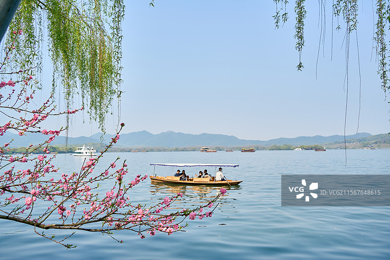 春天，杭州西湖游客乘船游玩，桃花前景图片素材