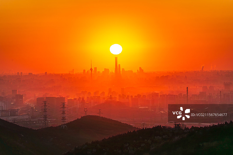 北京日出太阳升起下的城市轮廓图片素材
