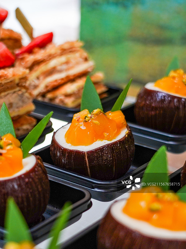 桌上盘子里椰壳形状甜点蛋糕的特写镜头图片素材