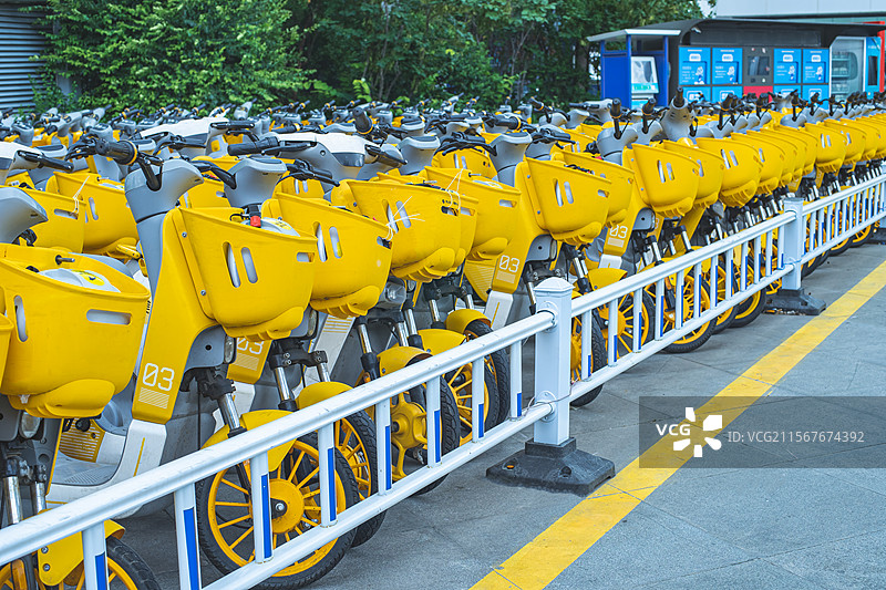 中国共享电动车拍摄主题，自行车停车场里，一排黄色的共享摩托车特写，户外白昼无人图像摄影图片素材