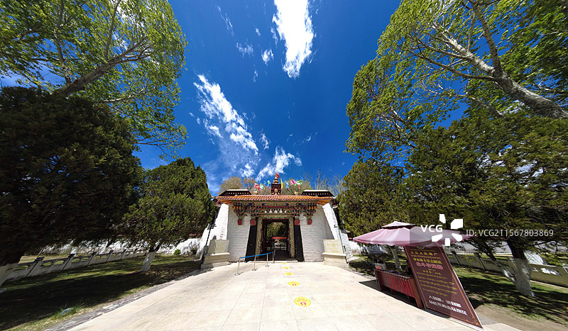 罗布林卡大门古朴庄重，色彩鲜明，饰有精美图案，周围绿树环绕，洋溢着藏式园林的独特韵味与宁静氛围。图片素材
