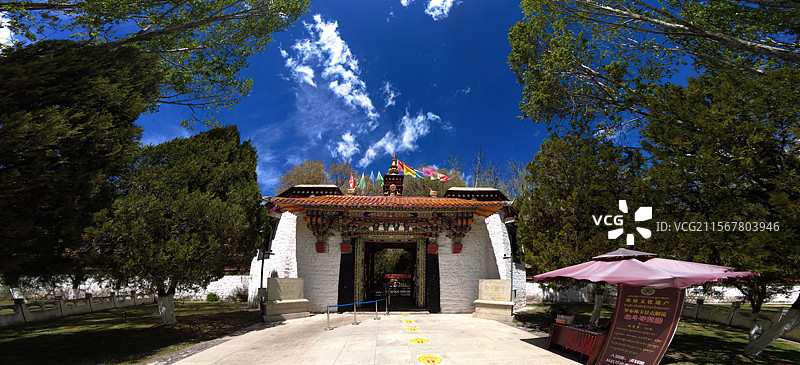 罗布林卡大门古朴庄重，色彩鲜明，饰有精美图案，周围绿树环绕，洋溢着藏式园林的独特韵味与宁静氛围。图片素材