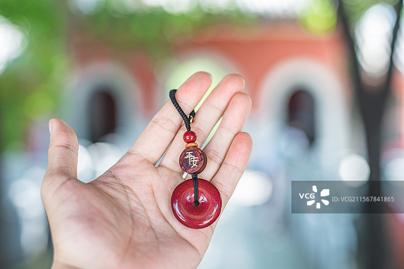 中国碧玉文化拍摄主题，手拎着拿着拖着着传统朱砂平安扣佩饰项坠艺术品工艺品，户外白昼无人图像摄影图片素材