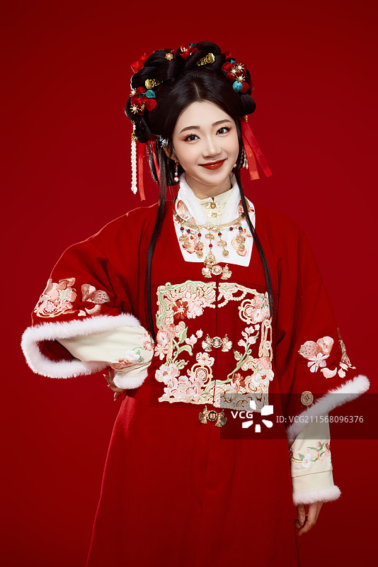 喜庆红色背景下身穿中国汉服的年轻女性图片素材