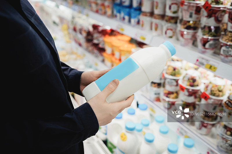 超市购物挑选牛奶图片素材