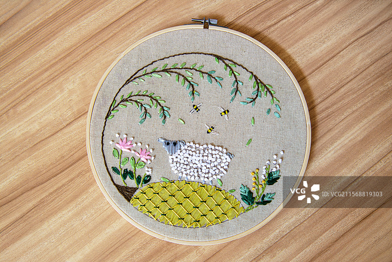 木纹桌子上的手工刺绣作品图片素材