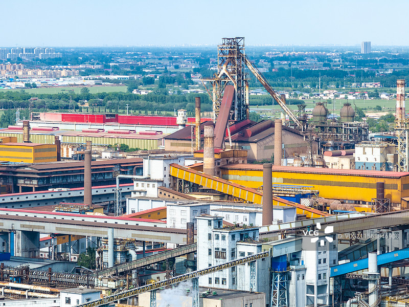 航拍蓝天下的安阳钢铁集团公司（安钢）钢铁焦化工厂厂区工业设施、冒烟的烟囱和厂房图片素材