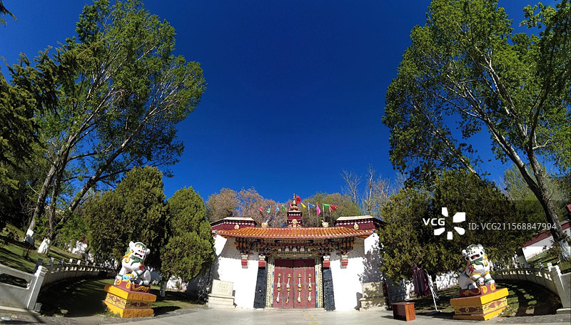 罗布林卡大门古朴庄重，色彩鲜明，饰有精美图案，周围绿树环绕，洋溢着藏式园林的独特韵味与宁静氛围。图片素材