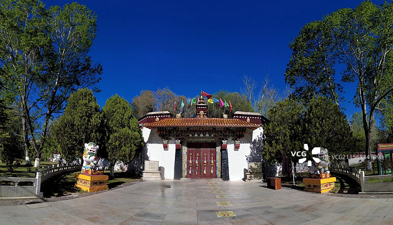 罗布林卡大门古朴庄重，色彩鲜明，饰有精美图案，周围绿树环绕，洋溢着藏式园林的独特韵味与宁静氛围。图片素材