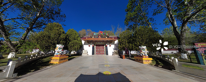 罗布林卡大门古朴庄重，色彩鲜明，饰有精美图案，周围绿树环绕，洋溢着藏式园林的独特韵味与宁静氛围。图片素材