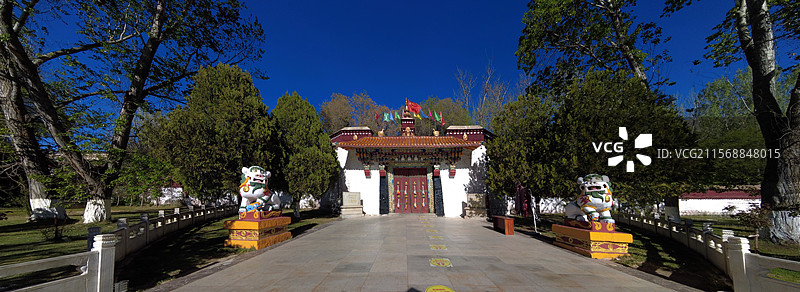 罗布林卡大门古朴庄重，色彩鲜明，饰有精美图案，周围绿树环绕，洋溢着藏式园林的独特韵味与宁静氛围。图片素材