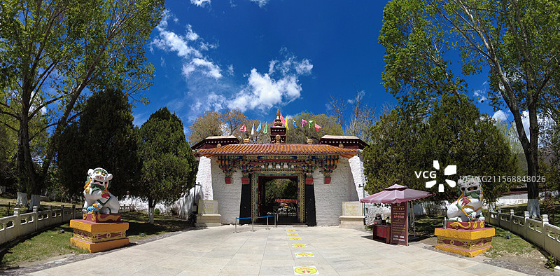 罗布林卡大门古朴庄重，色彩鲜明，饰有精美图案，周围绿树环绕，洋溢着藏式园林的独特韵味与宁静氛围。图片素材
