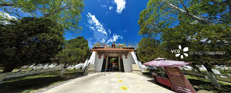 罗布林卡大门古朴庄重，色彩鲜明，饰有精美图案，周围绿树环绕，洋溢着藏式园林的独特韵味与宁静氛围。图片素材