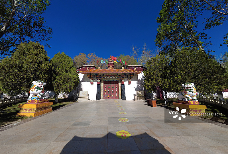 罗布林卡大门古朴庄重，色彩鲜明，饰有精美图案，周围绿树环绕，洋溢着藏式园林的独特韵味与宁静氛围。图片素材
