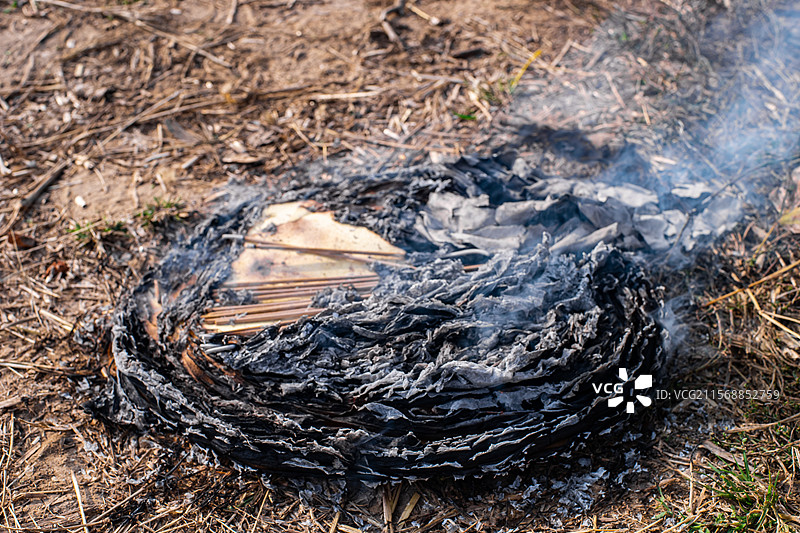 中国宗教信仰拍摄主题，清明节坟地墓地前燃烧的一堆一沓黄纸，户外白昼无人图像摄影图片素材