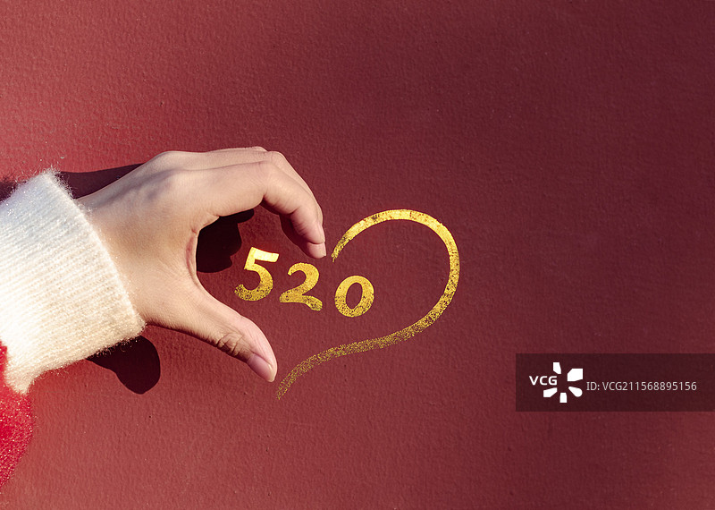 手与墙上的520鎏金字拼出一个完整的心形图片素材