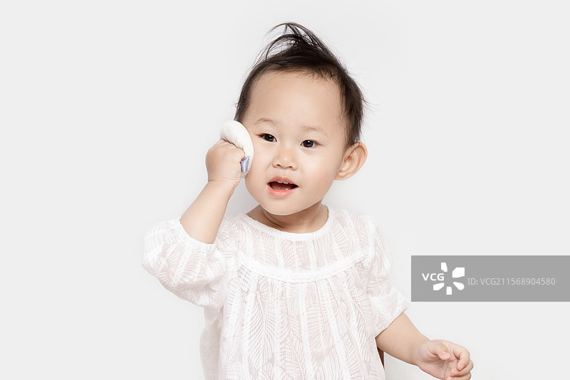 正在用粉扑化妆的两岁女孩图片素材