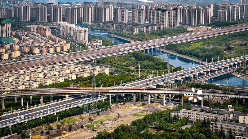 城市中多列高铁通过和立交桥相交的路轨进站图片素材