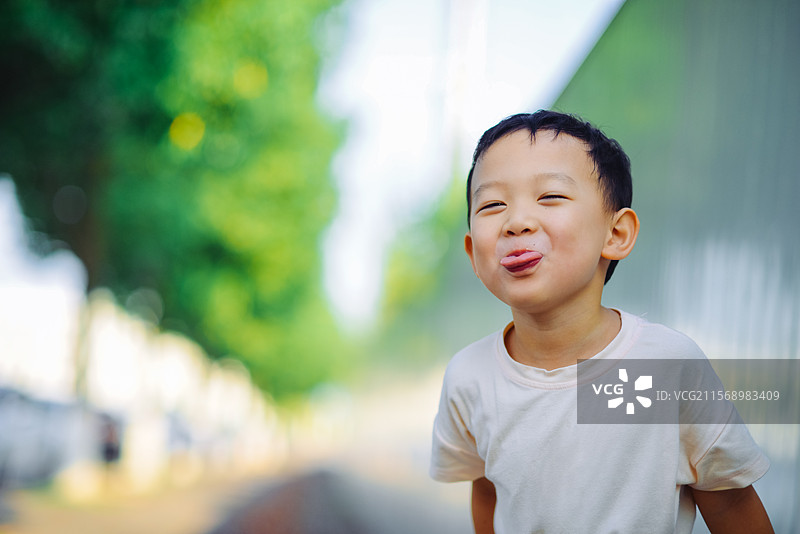 一个调皮吐舌头的5岁亚洲男孩图片素材