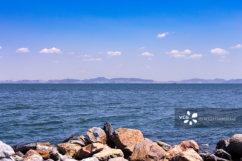 大连东港海岸远望海面和远处山峦图片素材