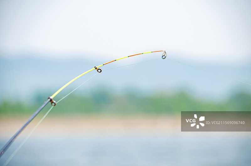 中国钓鱼垂钓拍摄主题，河流湖水中海竿阀杆竿稍弯曲的鱼线漂浮的鱼漂鱼浮子渔具，户外白昼无人图像摄影图片素材
