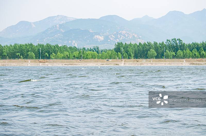 中国非都市风光拍摄主题，山东泰安大汶河景区平静的河面和河岸对面的树林，户外白昼无人图像摄影图片素材