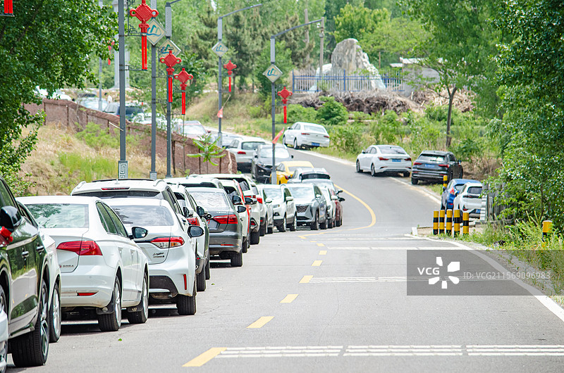 中国汽车交通拍摄主题，乡村道路上两侧停靠的汽车正在排队，户外白昼无人图像摄影图片素材