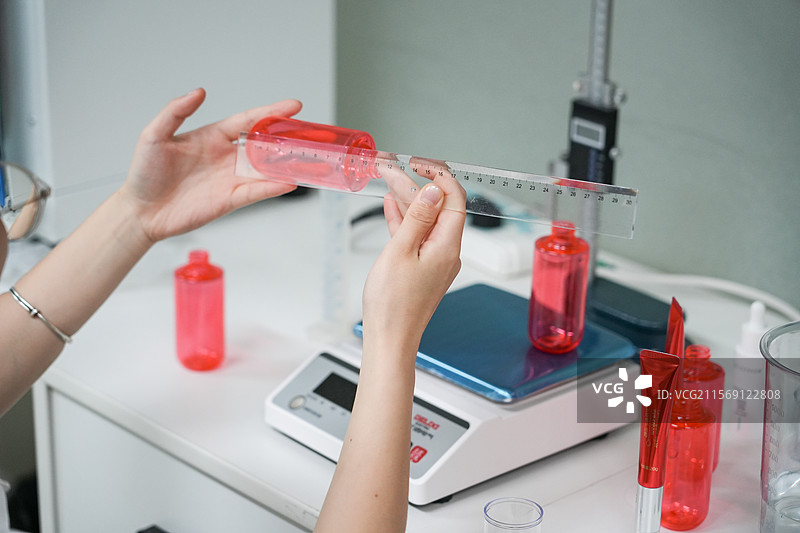 产品检测员正在检查护肤品空瓶图片素材