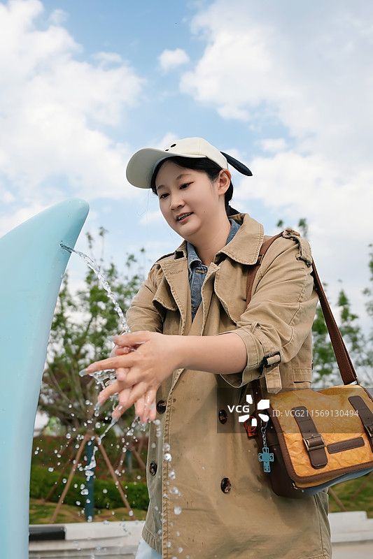 公园喷泉洗手的女孩图片素材