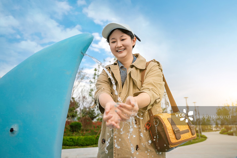 公园喷泉洗手的女孩图片素材
