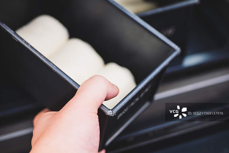 手拿面包模具中的面团图片素材