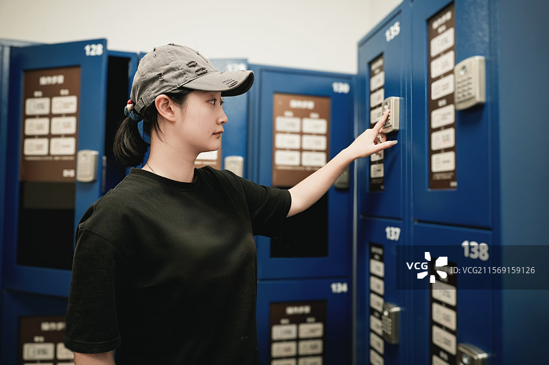 女子使用储物柜数字密码锁图片素材