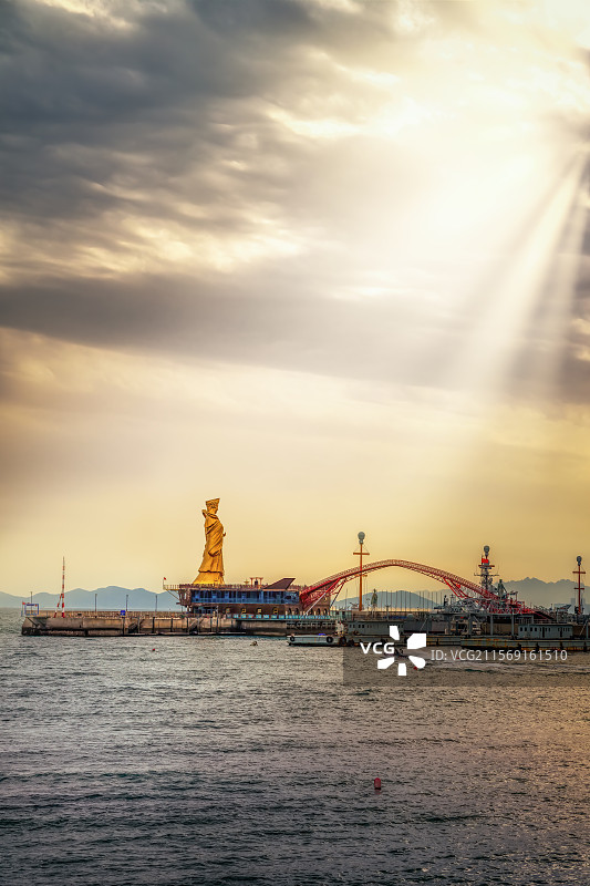 金色雕塑与落日码头图片素材