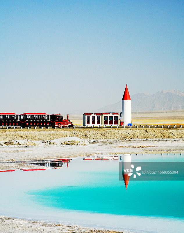 蓝色湖面上倒映出红色的小火车图片素材