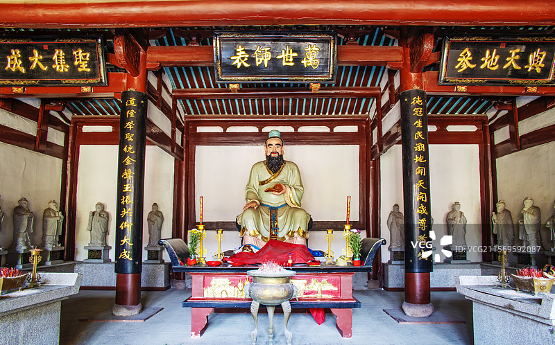 位于中国福建省福州市螺洲古镇悬挂着与天地参、圣集大成、万世师表牌匾的孔庙大成殿里的孔子塑像图片素材