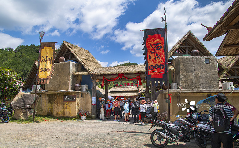 蓝天白云下烈日酷暑里游人涌入4A级旅游景区福建省三明市远古侠客江湖山寨式风格的侠天下售票处图片素材