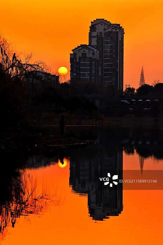 夕阳下淮南市田家庵区老龙眼水库的建筑倒影图片素材