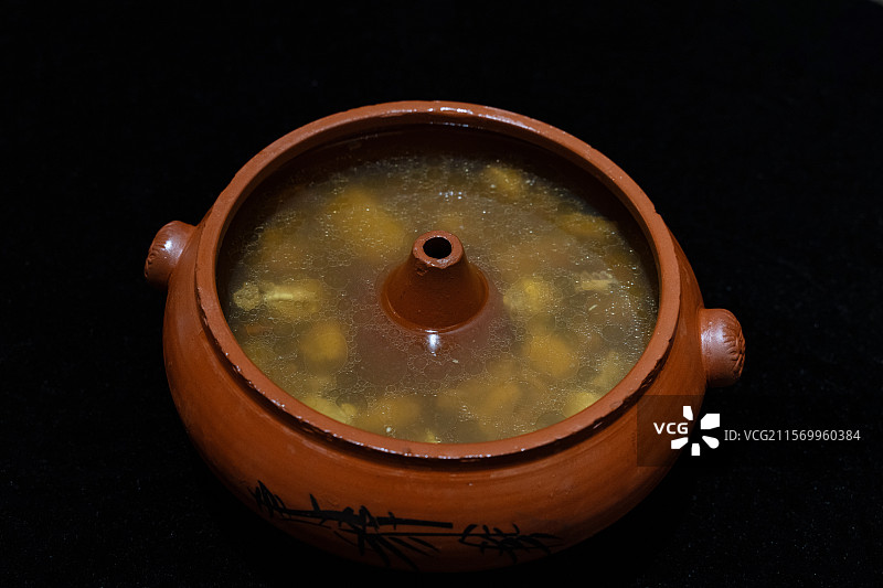 黑色背景下的中式菜肴，火锅鸭汤图片素材