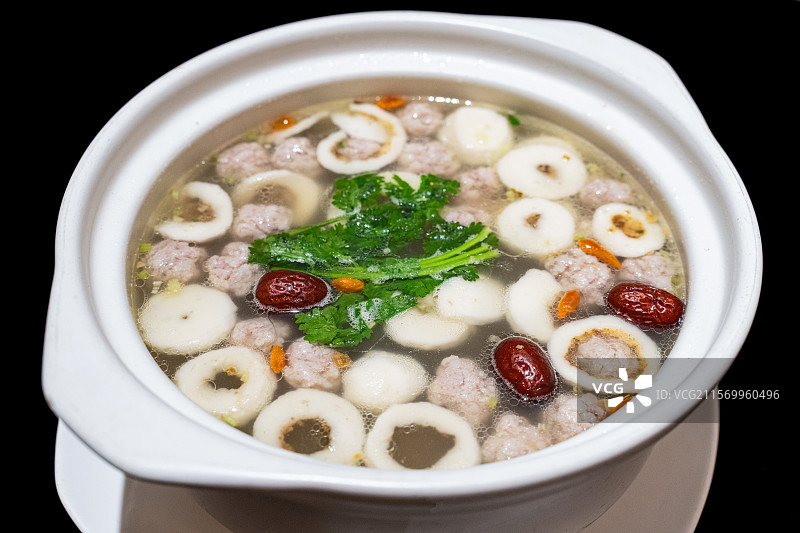 黑色背景白色餐具里的各种丸子组成的汤图片素材