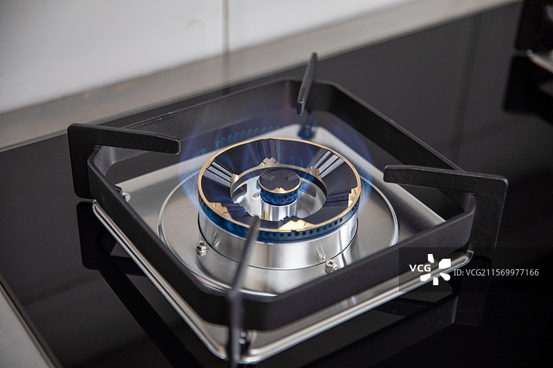 厨房燃烧蓝色火焰的天然气灶头的高角度视图图片素材