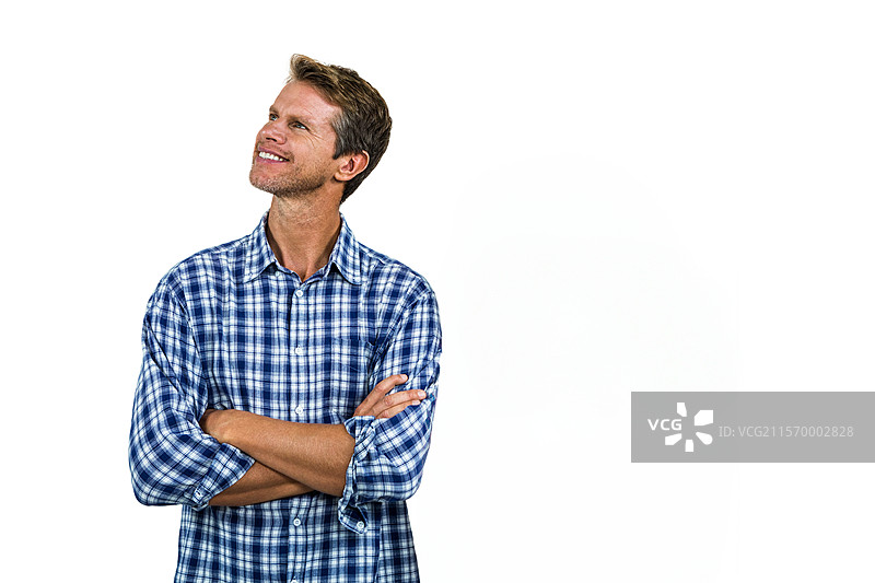 微笑的男子站在白色无缝背景前，展现放松的姿势，留有空白空间图片素材