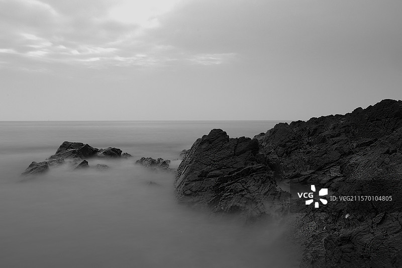 长曝光黑白光影雾锁礁石的静谧之美图片素材
