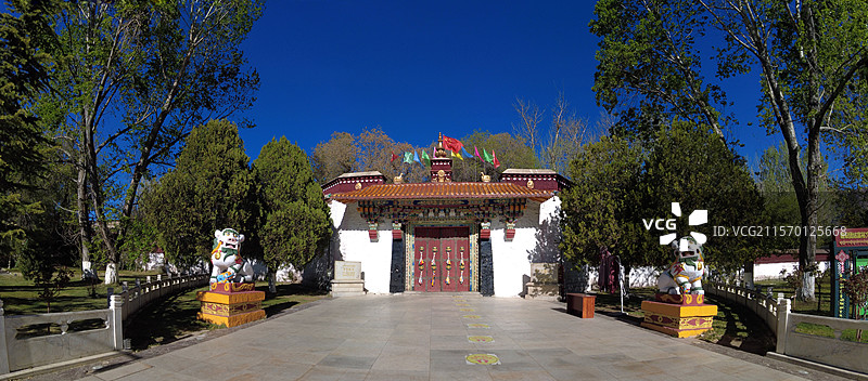 罗布林卡大门古朴庄重，色彩鲜明，饰有精美图案，周围绿树环绕，洋溢着藏式园林的独特韵味与宁静氛围。图片素材