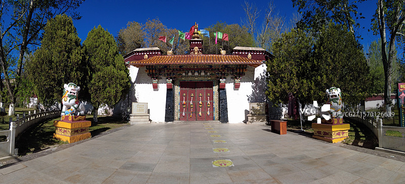 罗布林卡大门古朴庄重，色彩鲜明，饰有精美图案，周围绿树环绕，洋溢着藏式园林的独特韵味与宁静氛围。图片素材