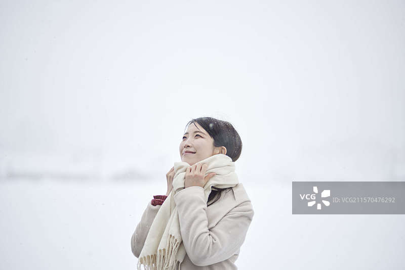穿着围巾的日本女性在冬季的雪国中站立图片素材