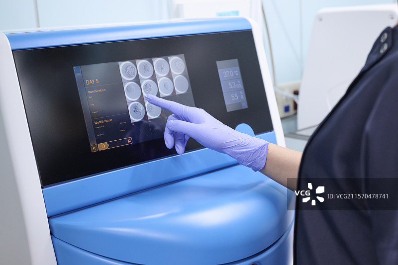 一名胚胎学家在培养箱中观察受精卵。图片素材