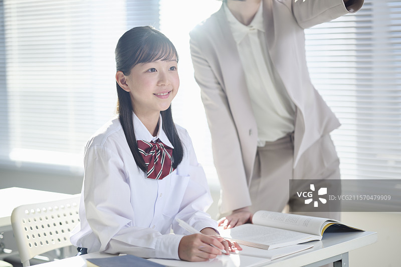 初中女孩在补习班老师的指导下学习图片素材
