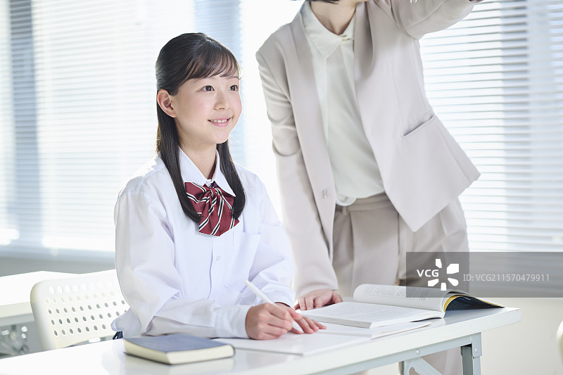 一名初中女孩正在接受辅导老师的教学图片素材