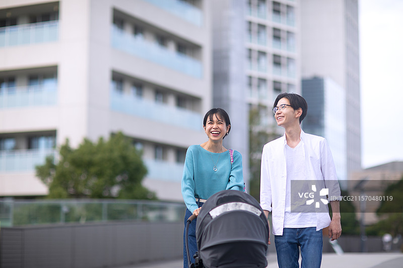 一对夫妇推着婴儿车散步图片素材