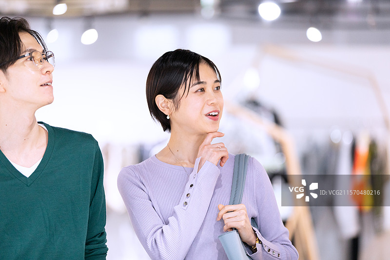 一对情侣在精品店朝同一个方向看。图片素材